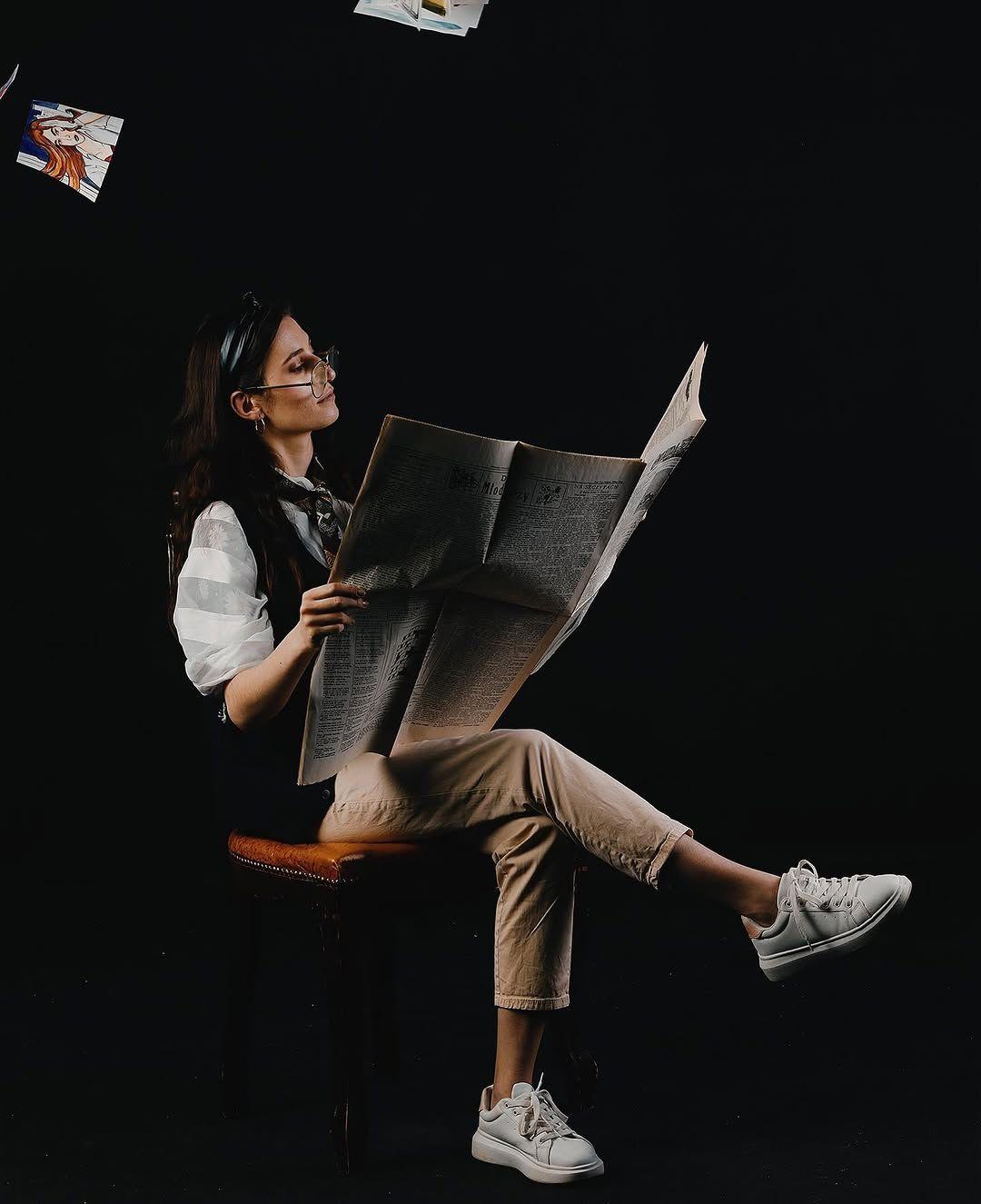 Natalia Guz w koncepcyjnej sesji studyjnej na czarnym tle — wokół unoszą się kartki i jej prace